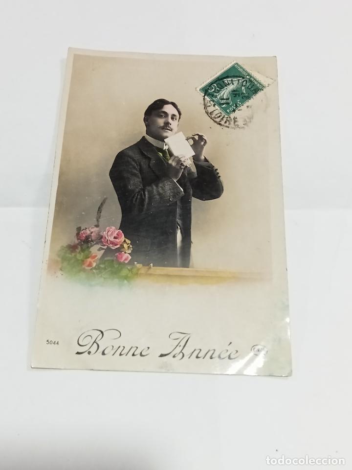 Cartoline: TARJETA POSTAL. FELICITACI&Oacute;N. JOVEN HOMBRE DE CHAQUETA CERRANDO CARTA JUNTO A FLORES