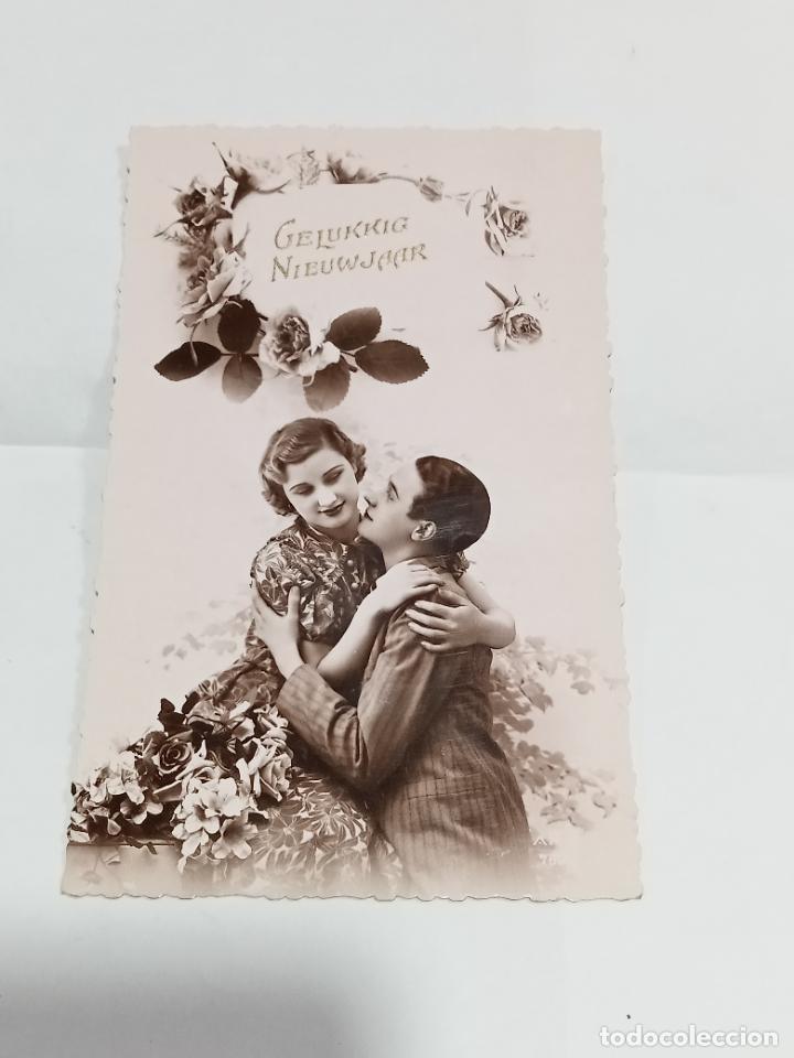 Postais: TARJETA POSTAL. JOVEN PAREJA DE ENAMORADOS ABRAZ&Aacute;NDOSE UNO AL OTRO RODEADOS DE FLORES