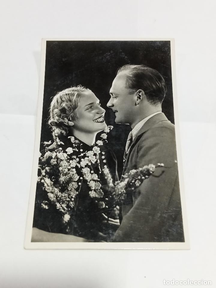 Cartoline: TARJETA POSTAL. PAREJA DE ENAMORADOS MIR&Aacute;NDOSE A LOS OJOS RODEADOS DE PEQUE&Ntilde;AS FLORES