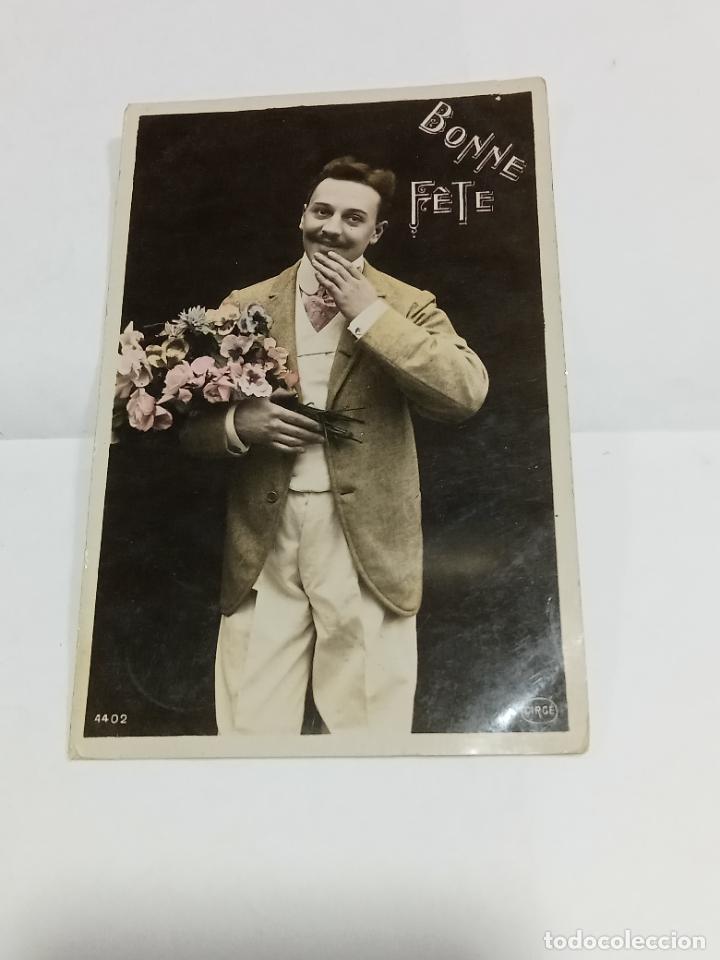 Cartoline: TARJETA POSTAL. JOVEN GAL&Aacute;N TIRANDO BESO CON RAMO DE FLORES EN SUS MANOS