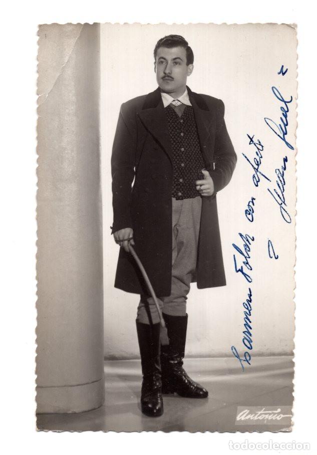 Postales: HOMBRE POSANDO FORMALMENTE CON UN ABRIGO LARGO, CHALECO ESTAMPADO Y BOTAS ALTAS