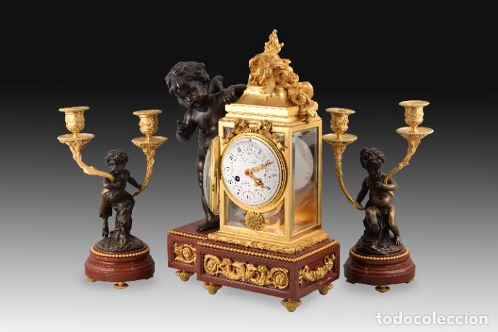 Horloges &agrave; remontage manuel: Guarnici&oacute;n de reloj y dos candelabros. Bronce, rouge griotte. Francia, s XIX, siguiendo a Clodion