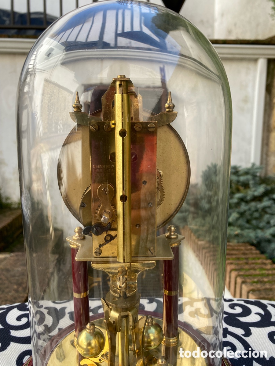 Relojes de carga manual: Reloj de mesa dorado con c&uacute;pula de cristal, pedestal de madera, fabricaci&oacute;n alemana.