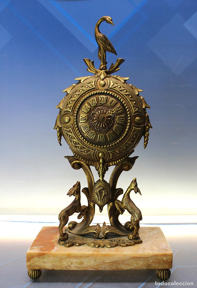 Relojes de carga manual: Antiguo reloj de bronce con peana de m&aacute;rmol.