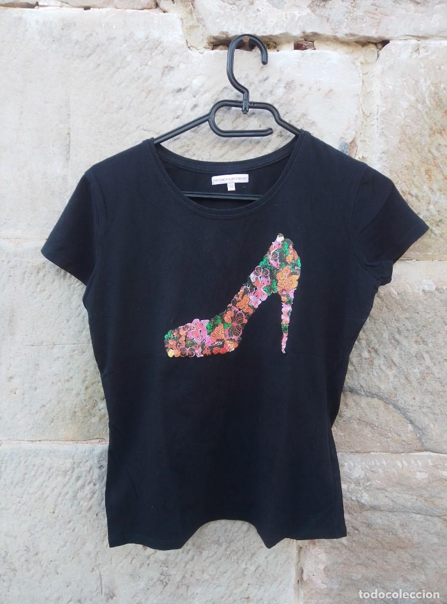 Segunda mano: Camiseta manga corta negra, con estampado de zapatos de tac&oacute;n con mariposas. Precchio colors concept