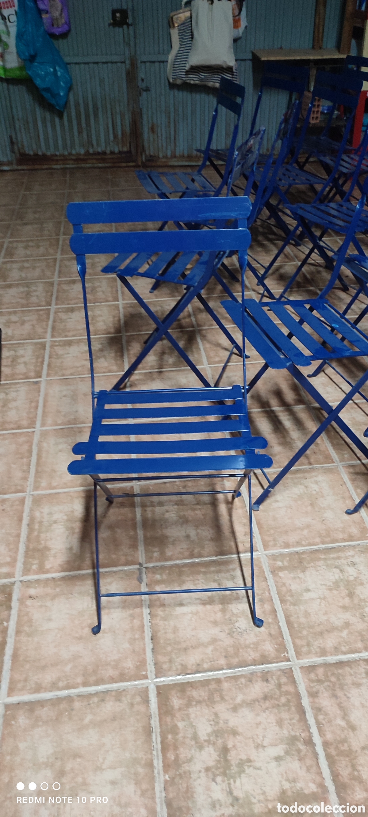Segunda mano: Sillas plegables de jard&iacute;n azules con publicidad detr&aacute;s de Cinzano.