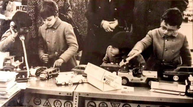 Fotografía de niños disfrutando en un puesto de juguetes en Valencia años 70