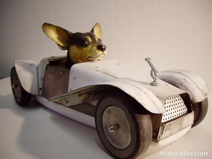 Escultura contemporánea de perro montado en un coche 