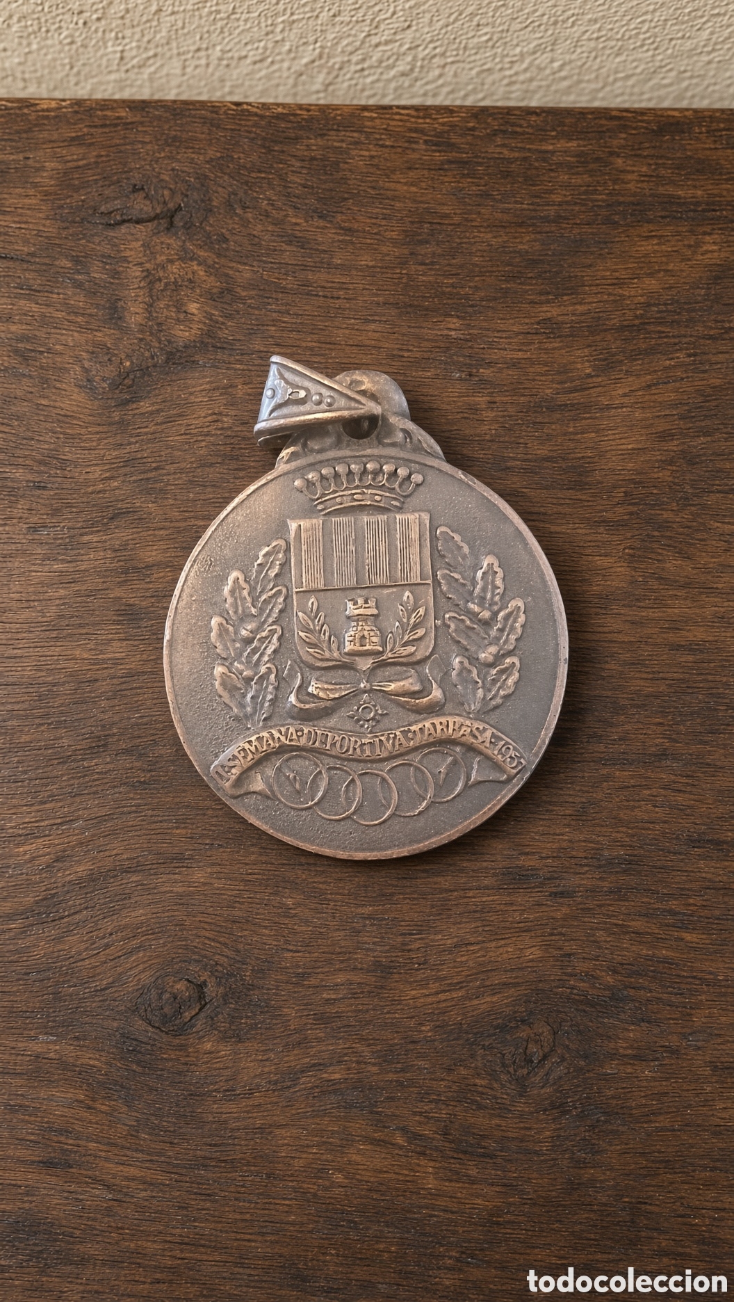 Trofeos y medallas: Medalla antigua deportiva Tarrasa 1957 Presenta un escudo central rodeado de laureles y los anillos