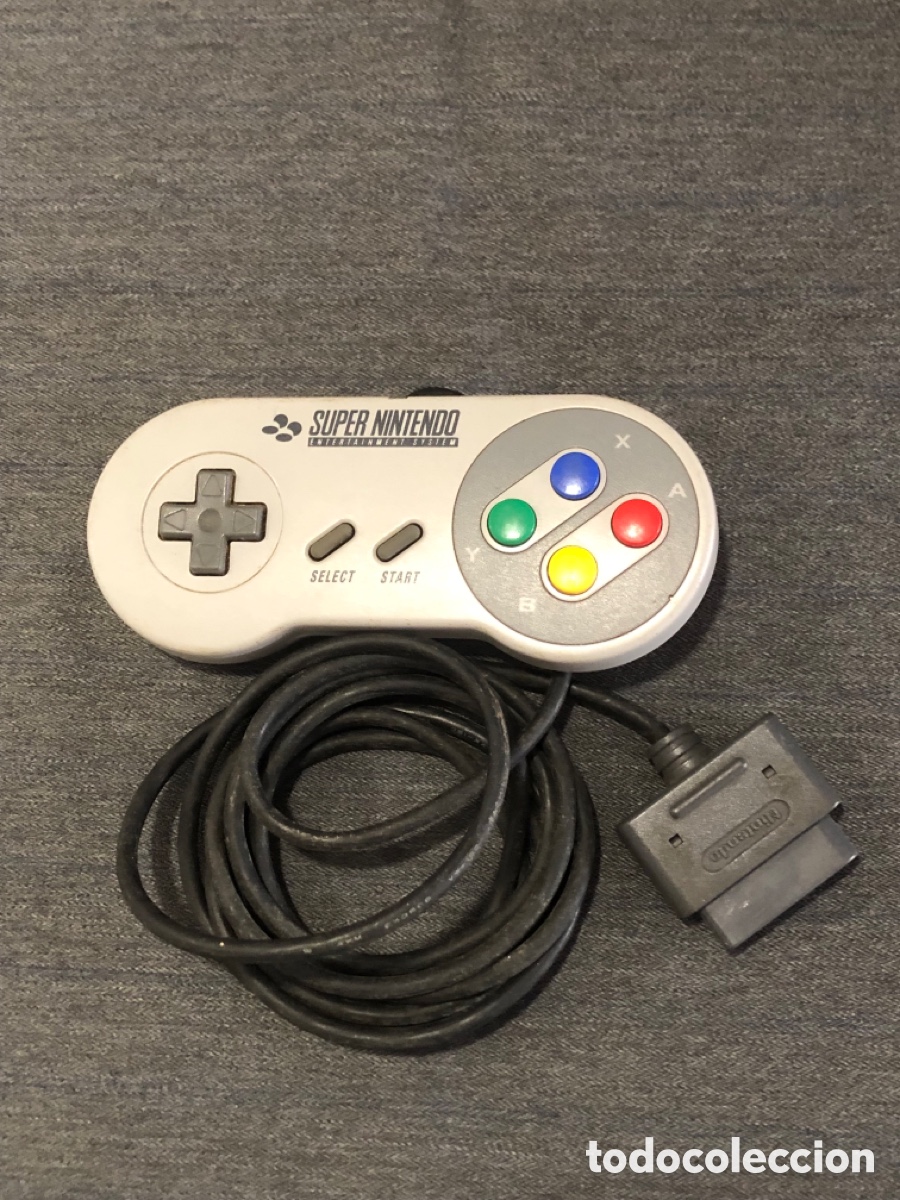 Videojuegos y Consolas: Controlador Super Nintendo Entertainment System (SNES) en color gris con botones de colores.