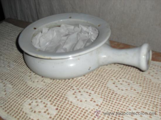 Vintage: muy antiguo orinal de porcelana blanca con agujeros en el borde.