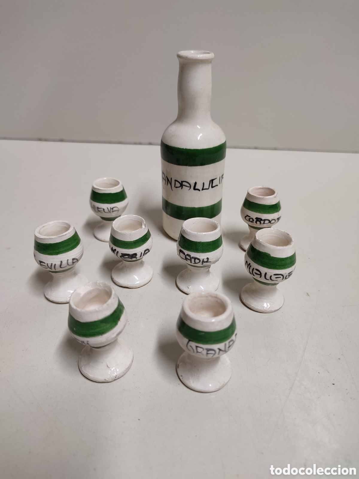 Vintage: Souvenir, recuerdo de Andaluc&iacute;a, botella de barro y 8 copas con nombres de las provincias andaluzas.