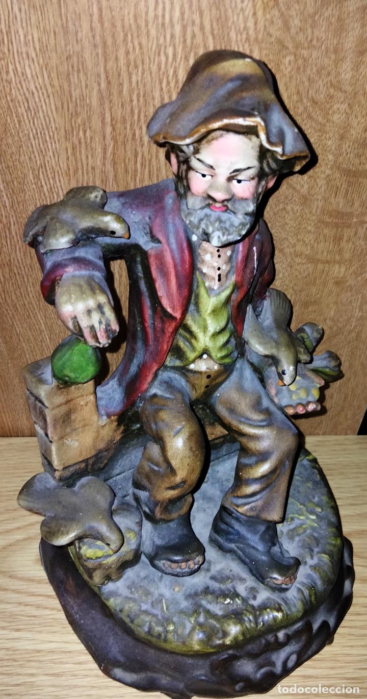 Vintage: Figura de Cer&aacute;mica Pintada a mano de un Vagabundo Sentado en un Banco con P&aacute;jaros.
