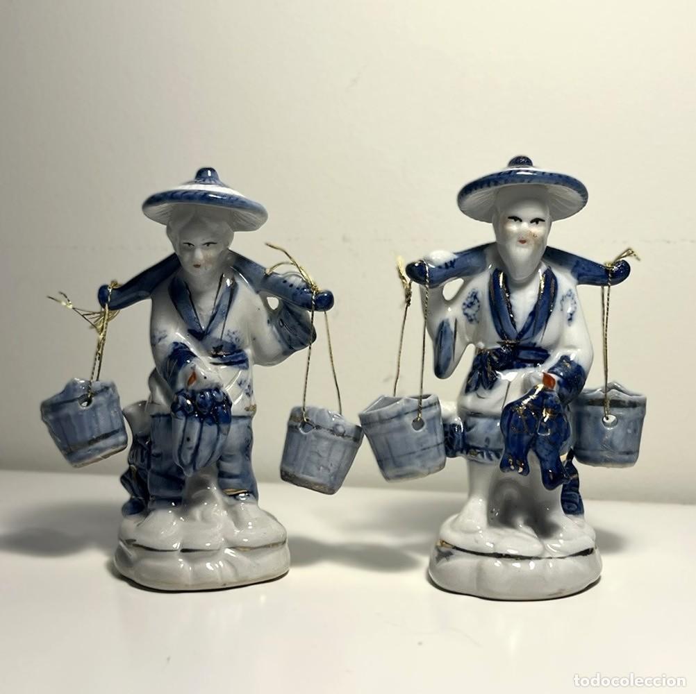 Vintage: Pareja de figuras de porcelana oriental. Pescadores con cubos. Azul, blanco y oro. S. XX