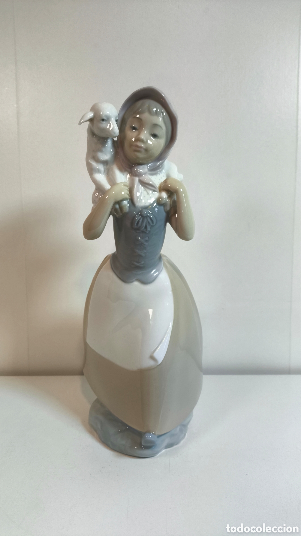 Vintage: Figura de porcelana Nao (Lladr&oacute;) que representa una pastorcita con pa&ntilde;uelo y un cordero sobre los ho
