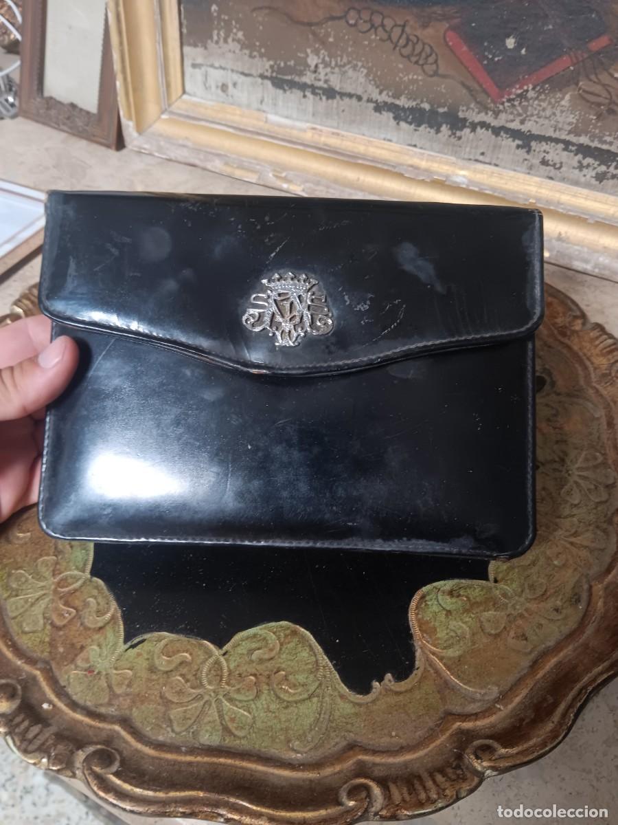 Vintage: bolso de mano vintage es de cuero negro y presenta un emblema plateado con un escudo de armas en el
