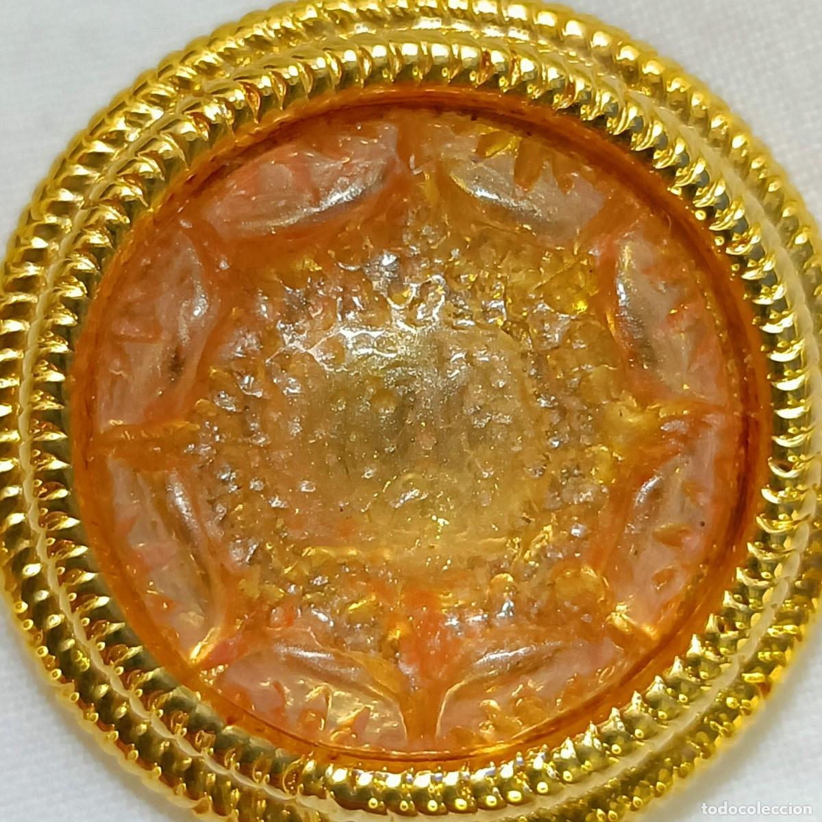 Vintage: Llamativo bot&oacute;n de metal dorado, bordes tallados, cabuj&oacute;n transl&uacute;cido color salm&oacute;n, de pie. 2,7 cm.