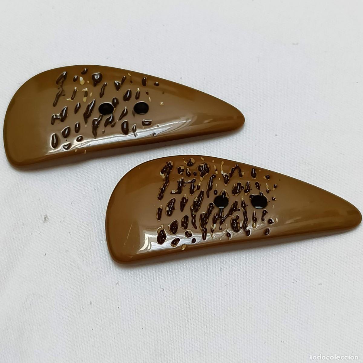 Vintage: 2 botones triangulares, resina brillante, verdes con motas negras y marfil, dos agujeros. 7,2 cm.