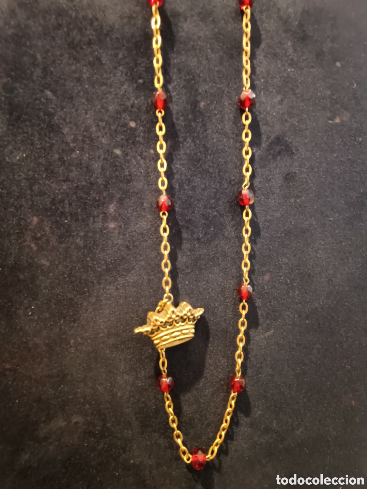 Vintage: Collar dorado largo rematado con una corona.