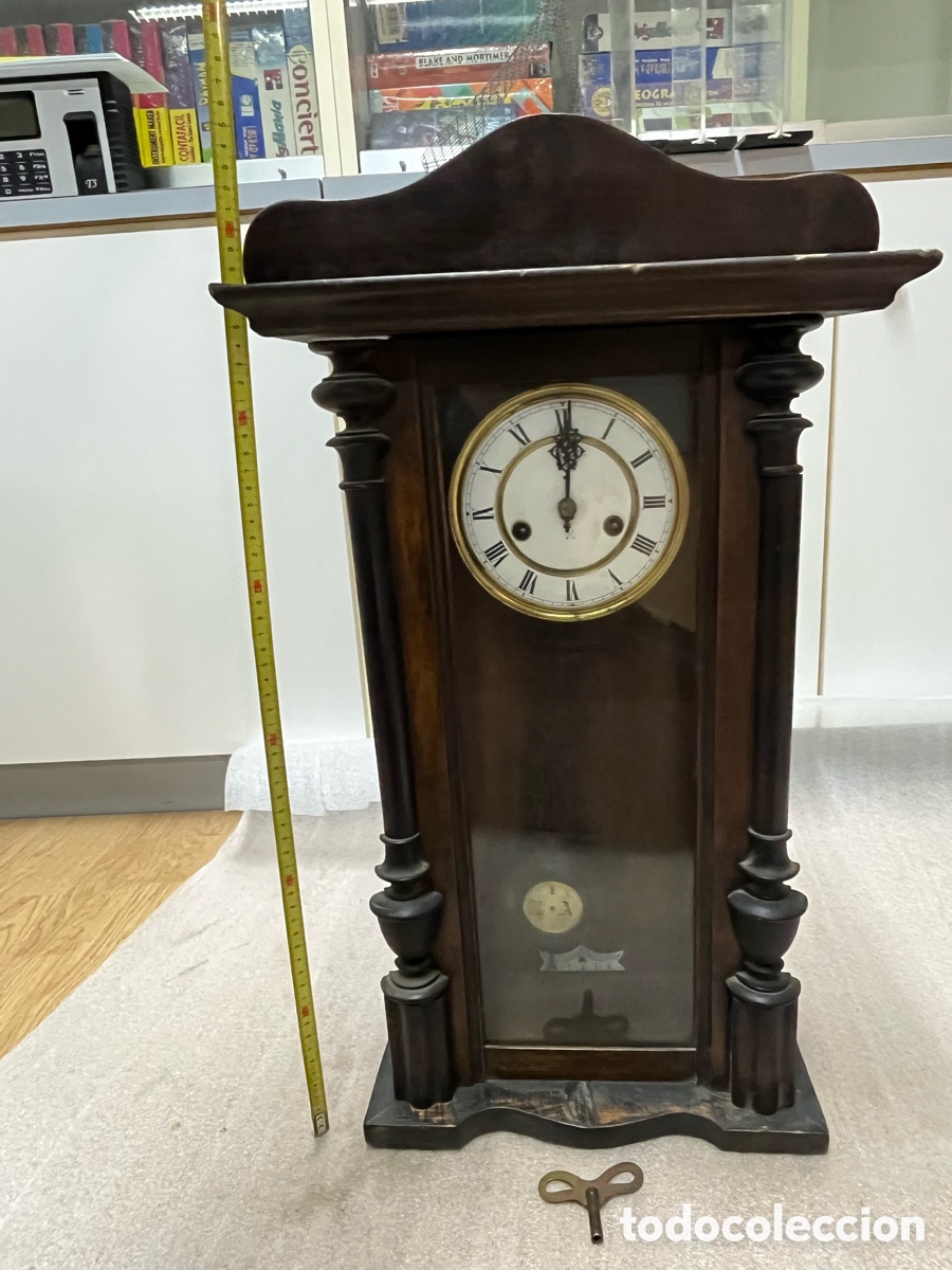 Vintage: Reloj de pared antiguo con p&eacute;ndulo y llave