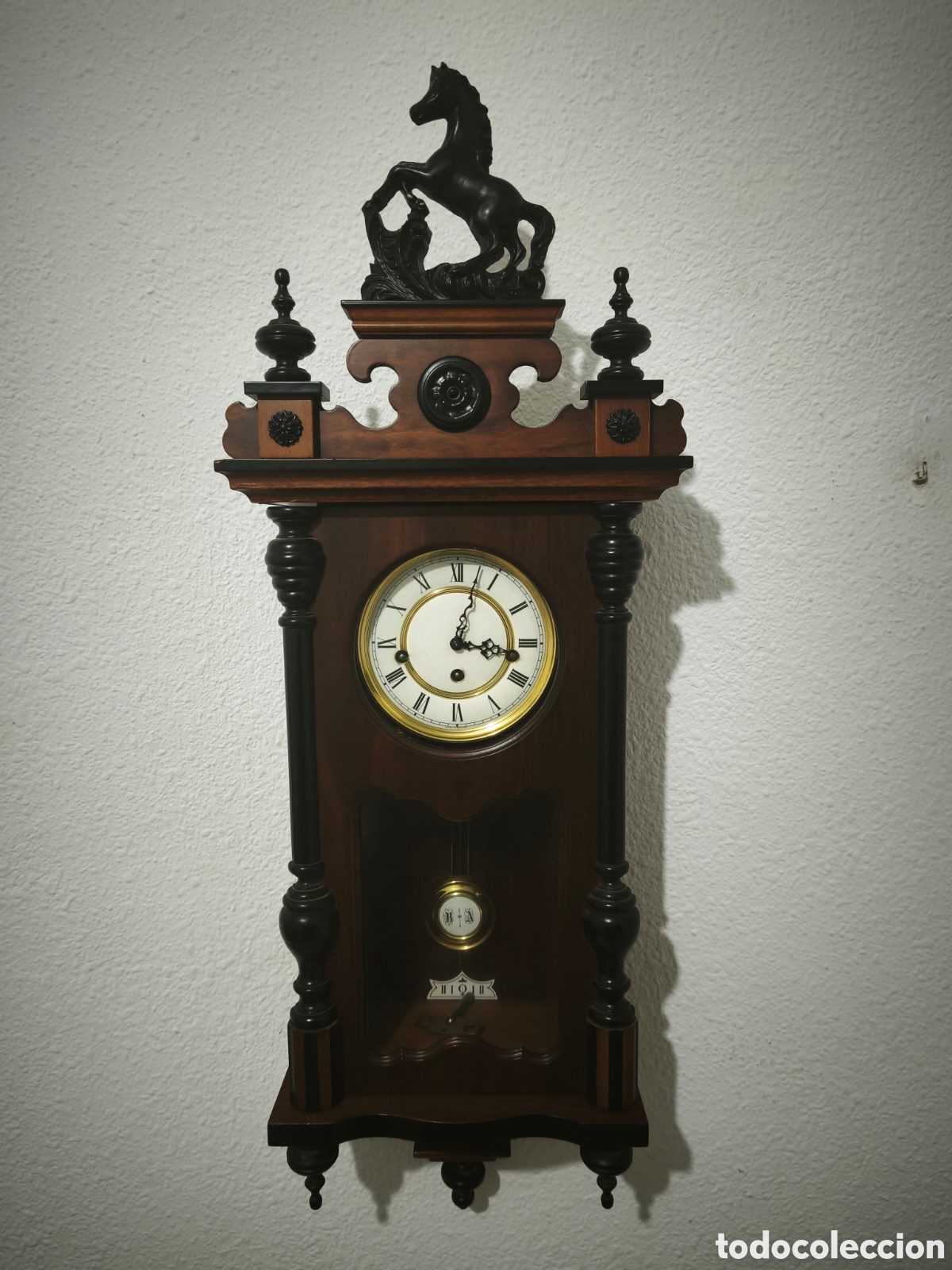 Vintage: Reloj de pared antiguo con p&eacute;ndulo y detalles de madera