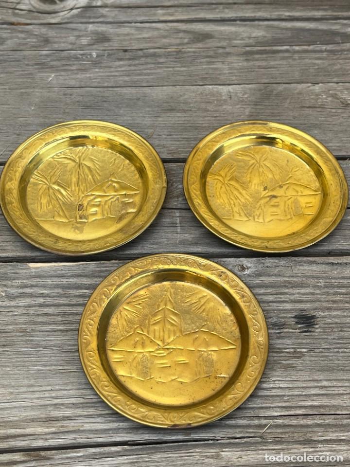 Vintage: Conjunto de tres platitos de metal dorado con motivos africanos.