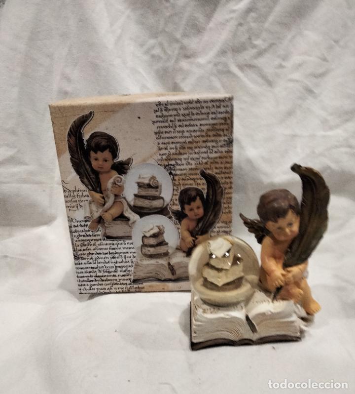 Vintage: Angel con pluma y bola de agua con libros