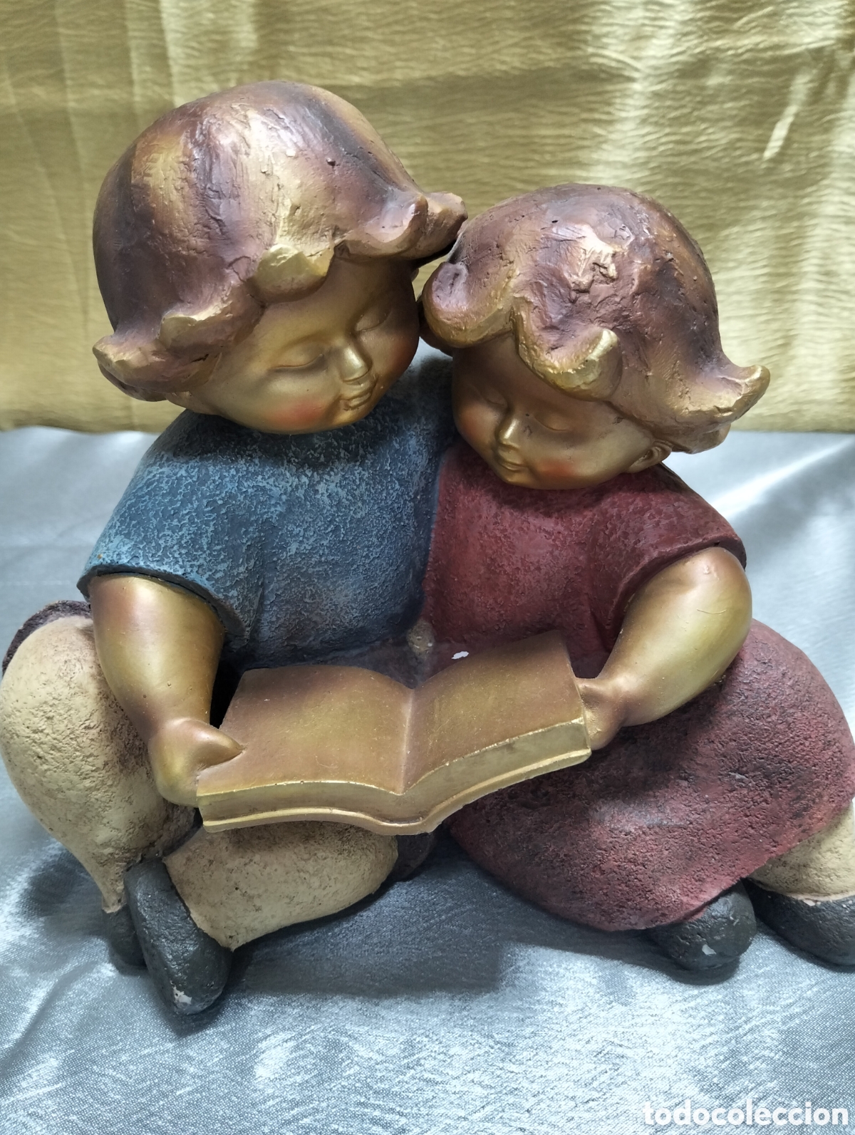 Vintage: una&nbsp;figura decorativa de colecci&oacute;n&nbsp;que representa a dos ni&ntilde;os leyendo juntos un libro.&nbsp;